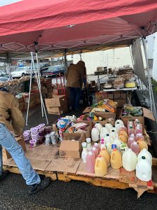 Two people sort through items under a tent.