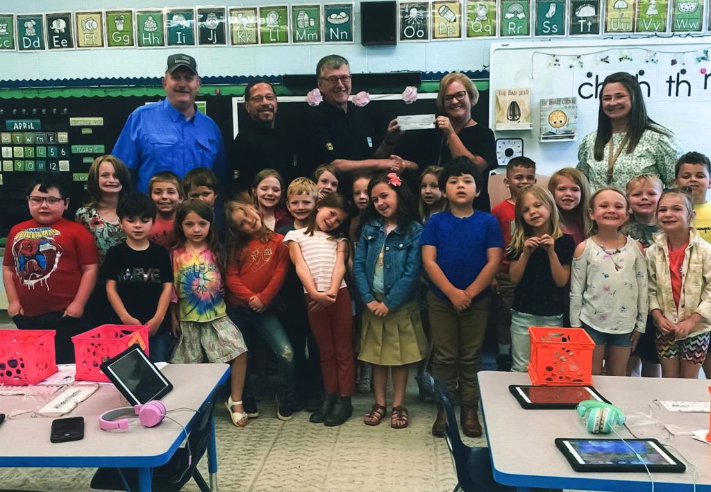 From top left: Ruritan members Billy Corns, Kenneth Reynolds and David Clement present a donation to Mrs. Whitlow, principal, Mrs. Barnhart and her kindergarten class.