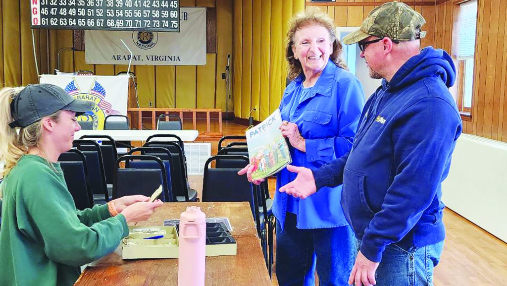 Paige Terry (left-right), Mary Dellenback Hill and her son Joshua B. Hill get in line to enjoy some of the hot Brunswick Stew and afterwards, to get some carryout containers of the stew for neighbors. (Photo by Jessica Wright)