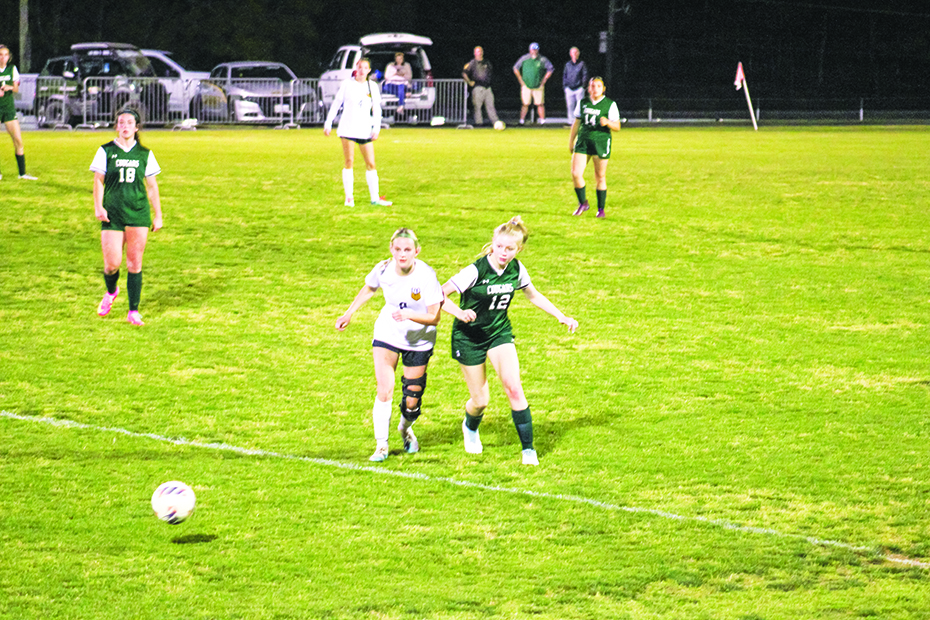 Daryl Lynn Combs runs past a Lady Bobcat for the ball.