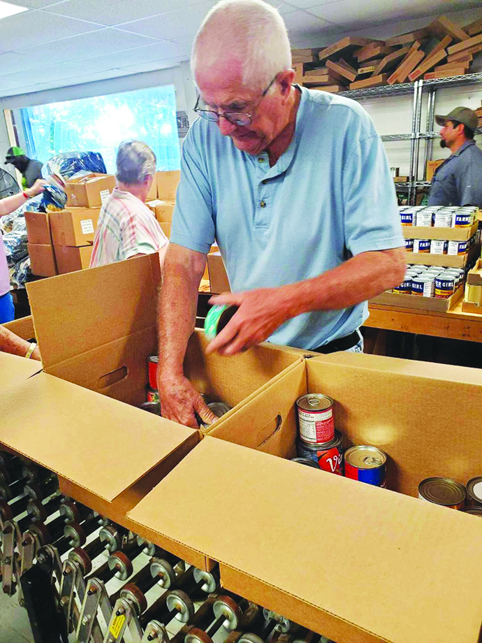 Volunteers unload pallets of food for those in need.