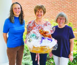 Robin Anthony (center) is pictured with the gift basket. The presenters are Master Gardeners Robin Reichelt (left) and Sherry Easterbrooks (right). 