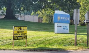 A sign recently added to the former hospital property indicates it is for sale in an online auction. (Photo by Pat Delaney)