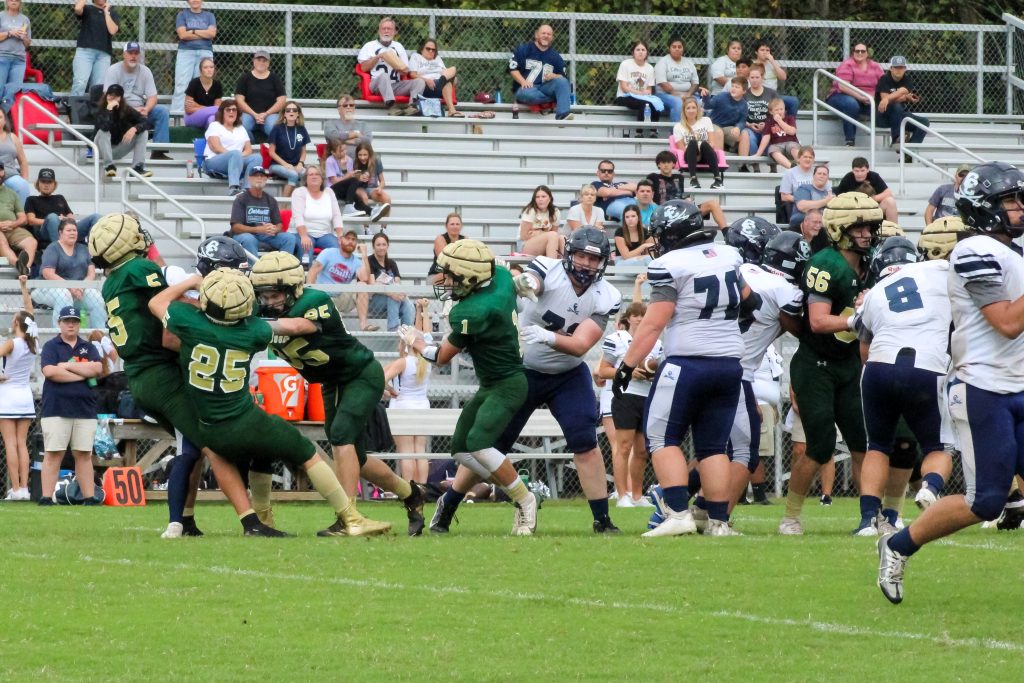 The Cougar defense swarms the Cavalier runner for a loss