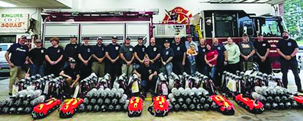 Members of the Patrick Springs, Woolwine, Fairystone, and Ararat volunteer fire departments stand in front of the Federal Emergency Management Agency (FEMA) grant haul