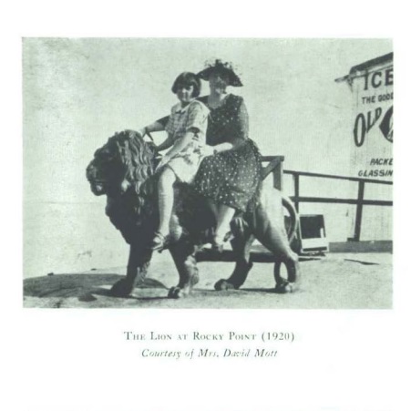 Photo of a girl and woman sitting on the statue Lion of Rocky Point (1920)