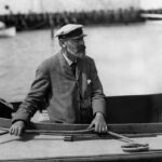 black and white photo of an elderly white man, identified at Nathanael Herreshoff, in a boat.