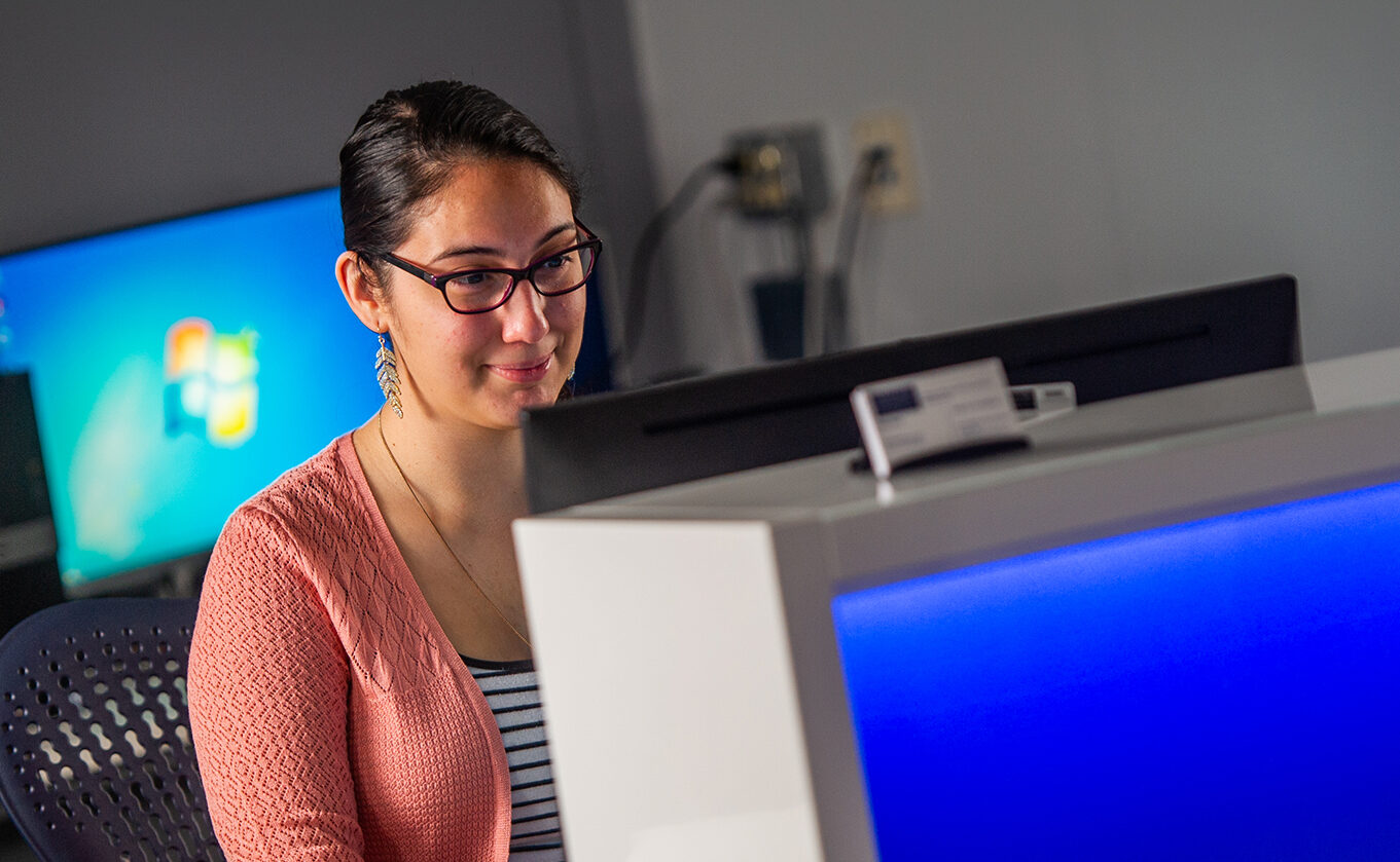 Student sitting in front of a computer in the computer lab.