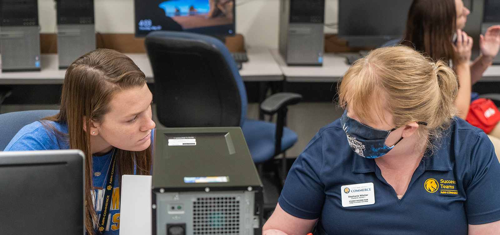 Success Teams member mentoring a student in the computer lab.