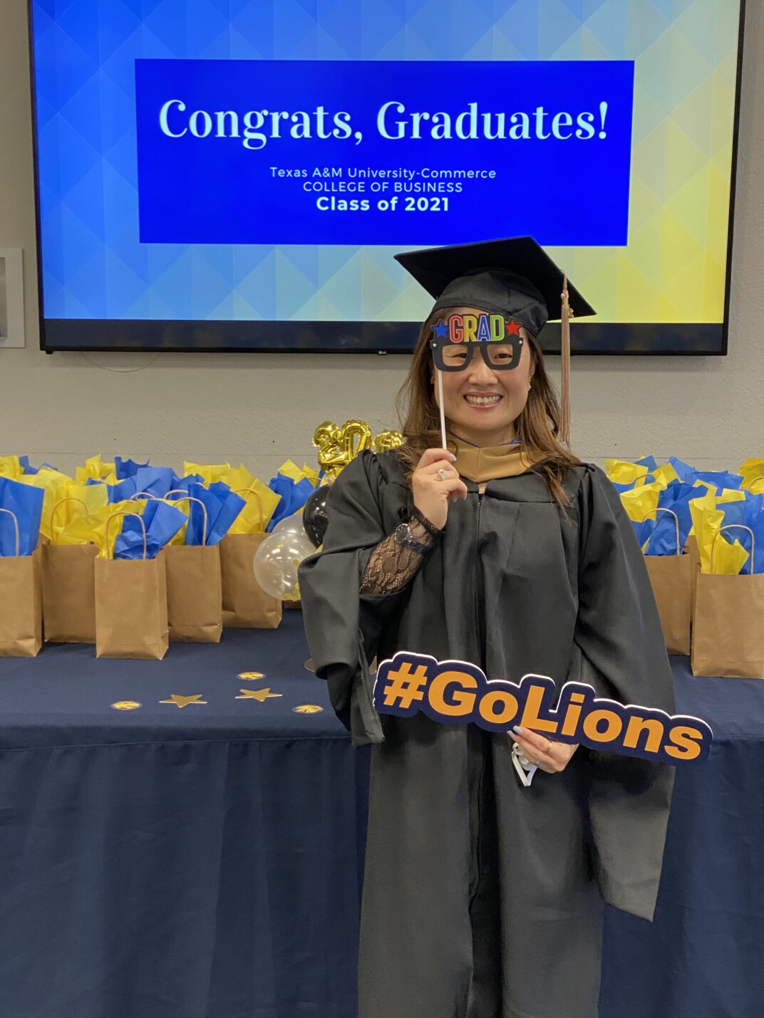 Young lady holding a sign saying go lionsGraduate Reception Spring 2021