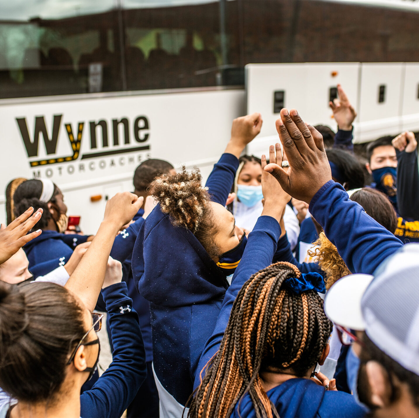 TAMUC track team by a bus.