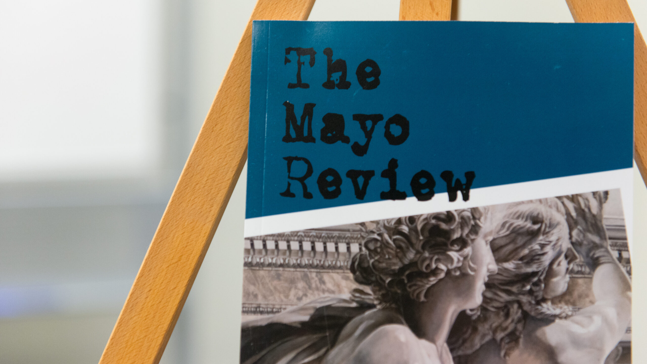 Book on a stand with title "The Mayo Review"