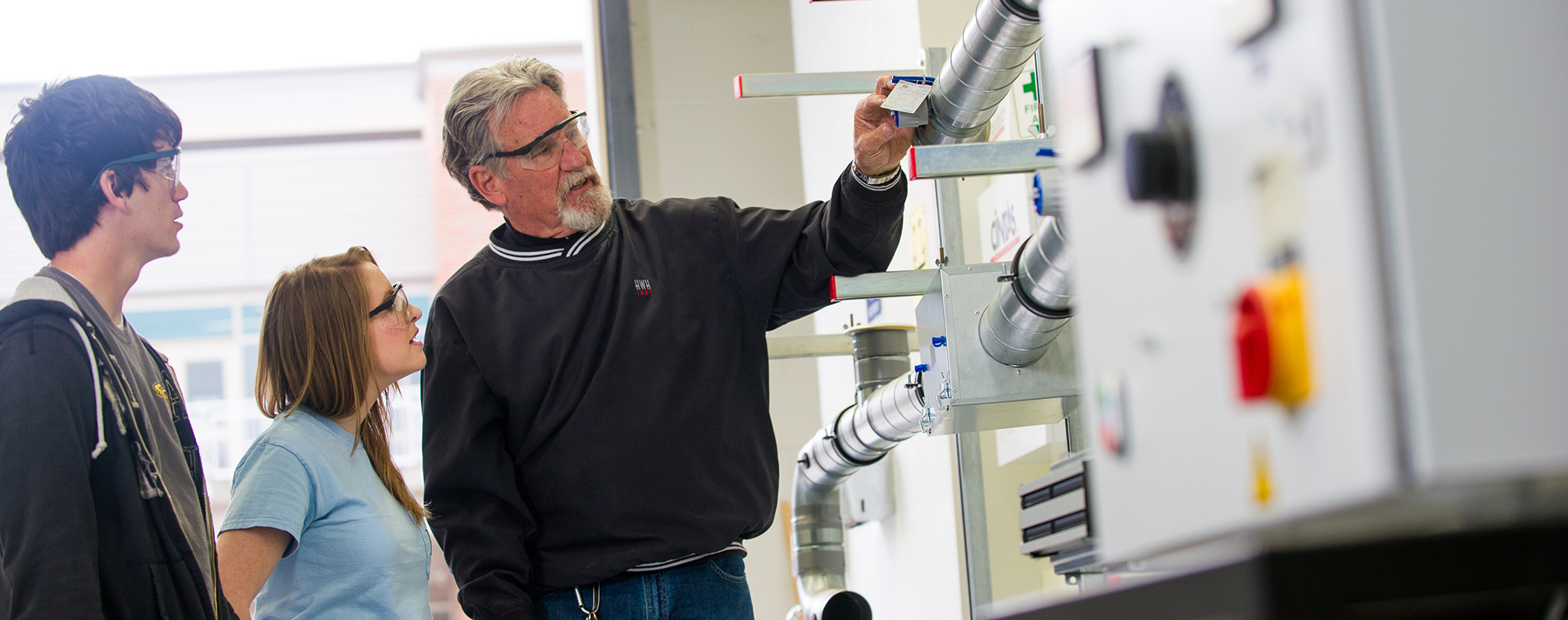 Instructor and students inspecting pipes.