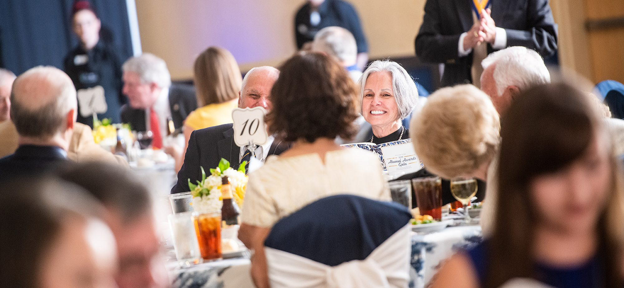 Many smiling people sitting at a banquet.