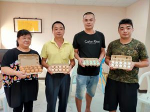 林志宏（中左二起）林鈺傑與林景詮，展示蛋雞所生產的各色雞蛋，是田園蛋品迎合消費市場的重大突破。（記者 辛澎祥/攝）