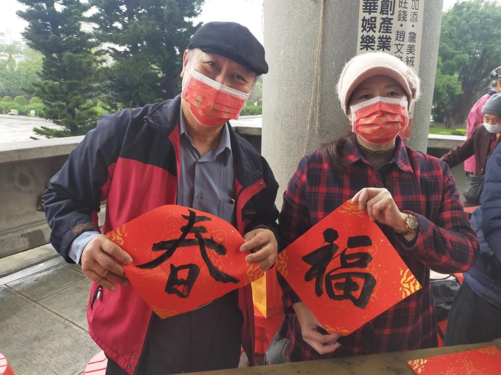 趙文雄老師（左）與詹美絨老師寫春聯向民眾賀年祝福。（記者 辛澎祥/攝）