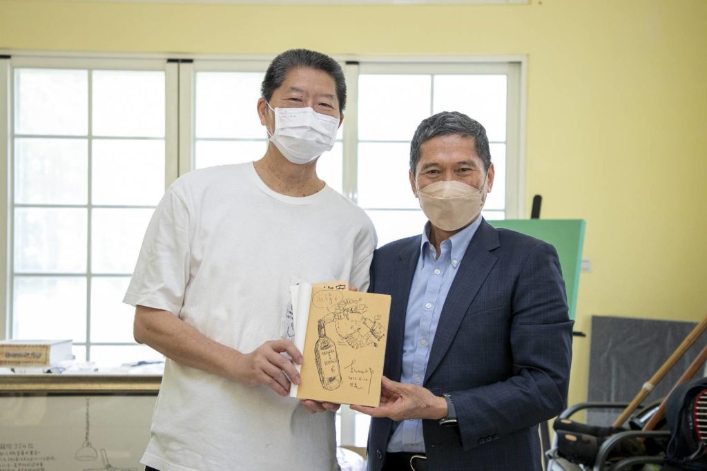 漫畫家敖幼祥(左)在描繪自身駐村經歷的作品《安古蘭遊記》內頁手繪簽名,致贈予李永得部長。