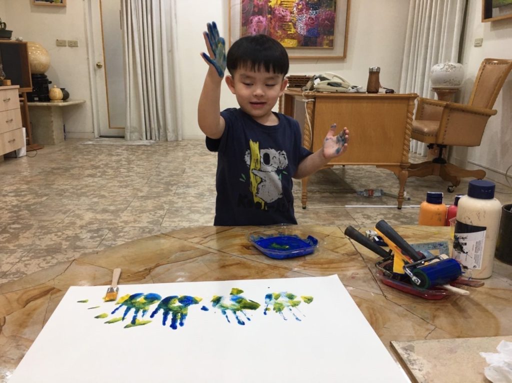 3歲的孫子，在謝蘭英的繪畫桃花源，大膽設色，用雙手盡情玩出一片天。(謝蘭英提供)