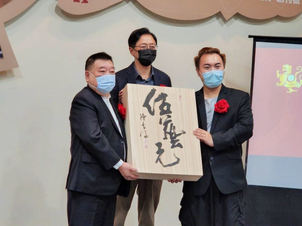 ▲在前行政院長張善政（中）的主持下，「伍藝元藝術雜誌」的發行人洪村騫（左）與社長洪偉倫以陳合成教授創作的雜誌版畫作品合影留念。（記者 辛澎祥/攝）