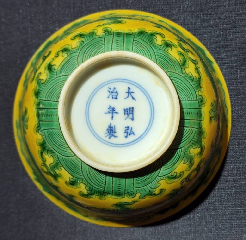 綠龍黃釉碗碗底有雙圈署以「大明弘治年製」楷體正字書寫，建構了明瓷珍品的真實呈現。（圖/曾國良 提供）