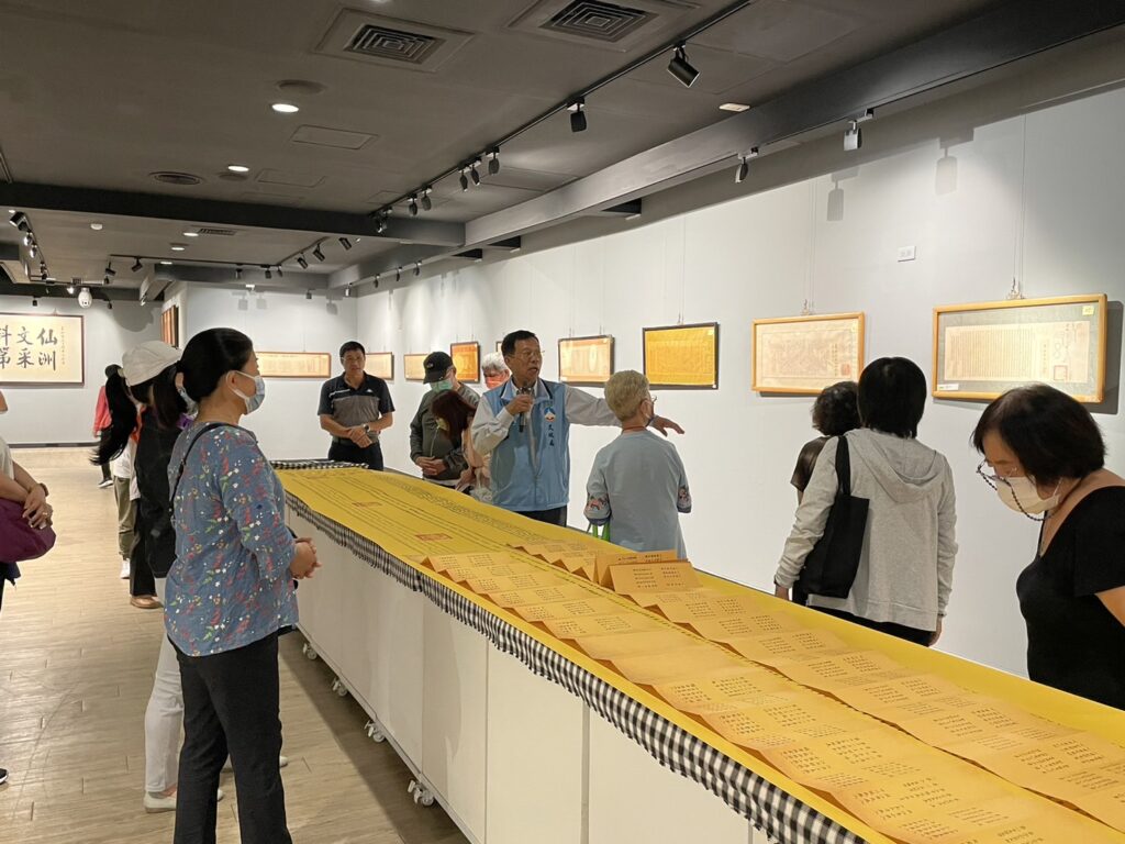 ▲金門文化局局長呂坤和(中)在特展中為民眾進行導覽。(圖/金門文化局 提供)