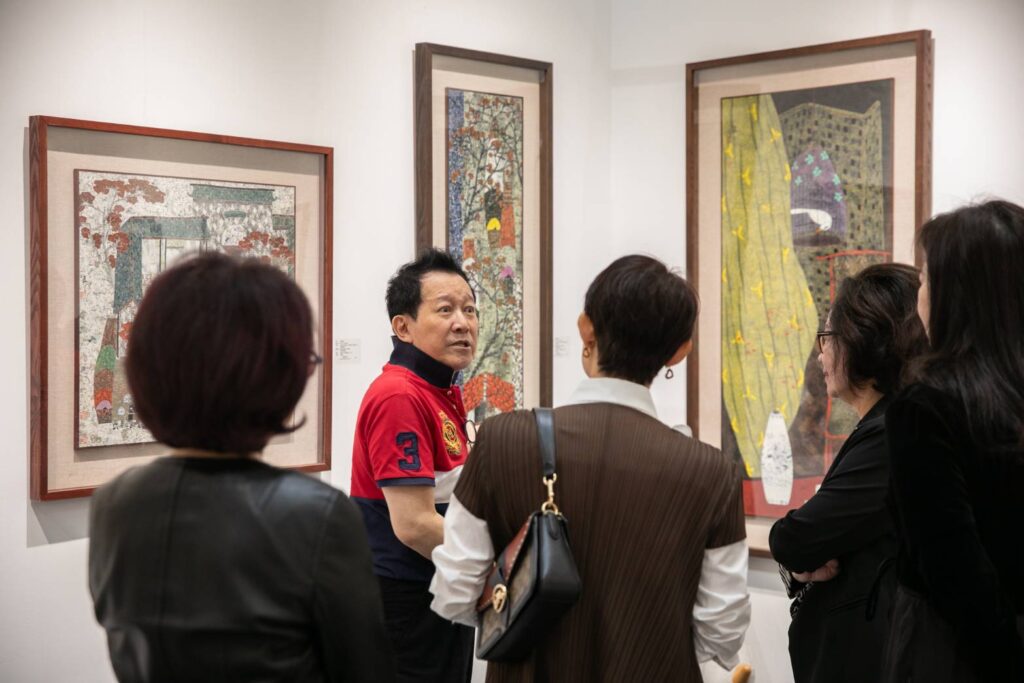 ▲張逸群理事長（左二）在藝博會展場為貴賓進行展品介紹導覽，展現他對藝術市場的專業觀察。（圖/畫廊協會 提供）