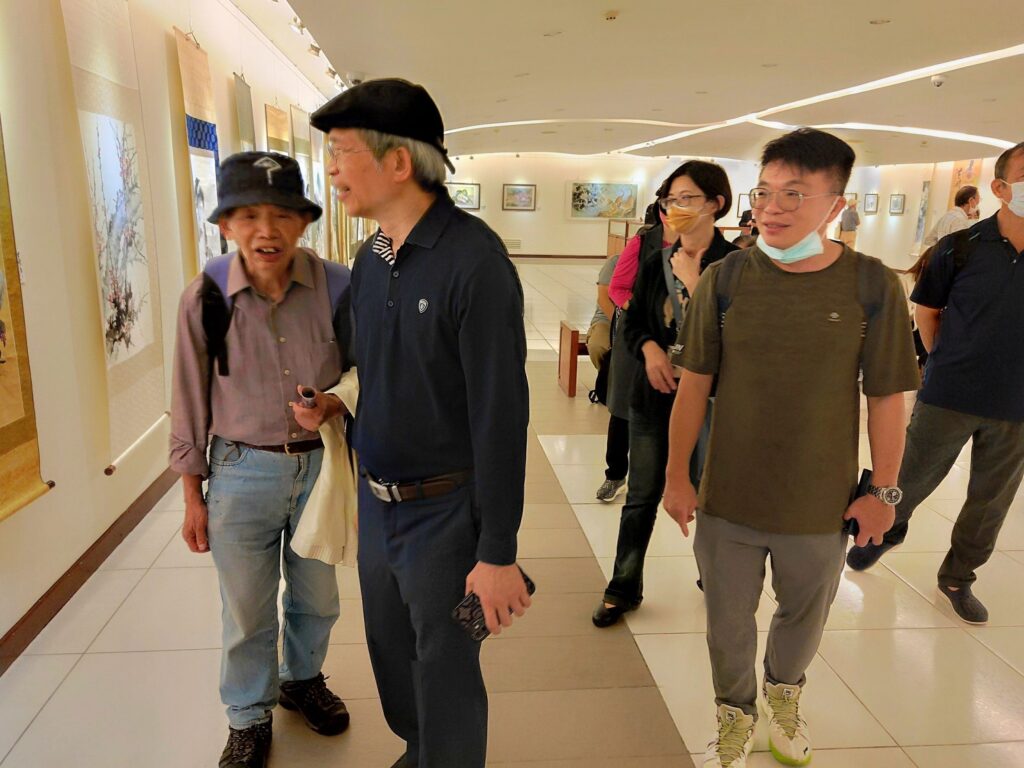 ▲前史博館館長現為臺藝大教授的廖新田(左二),特別安排他的學生到展場參觀學習洪曜平老師的水墨畫創作技巧。(記者 詹佳綺/攝)