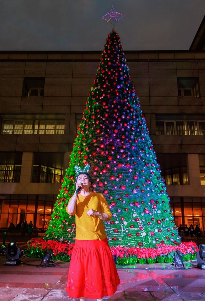 ▲聲樂家簡文秀在文大校園巨大耶誕樹旁高歌演唱，備受矚目。（圖/億光 提供）