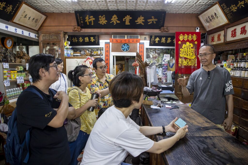 六安堂店主向新住民主持人介紹中藥鋪歷史。（圖/史博館提供）