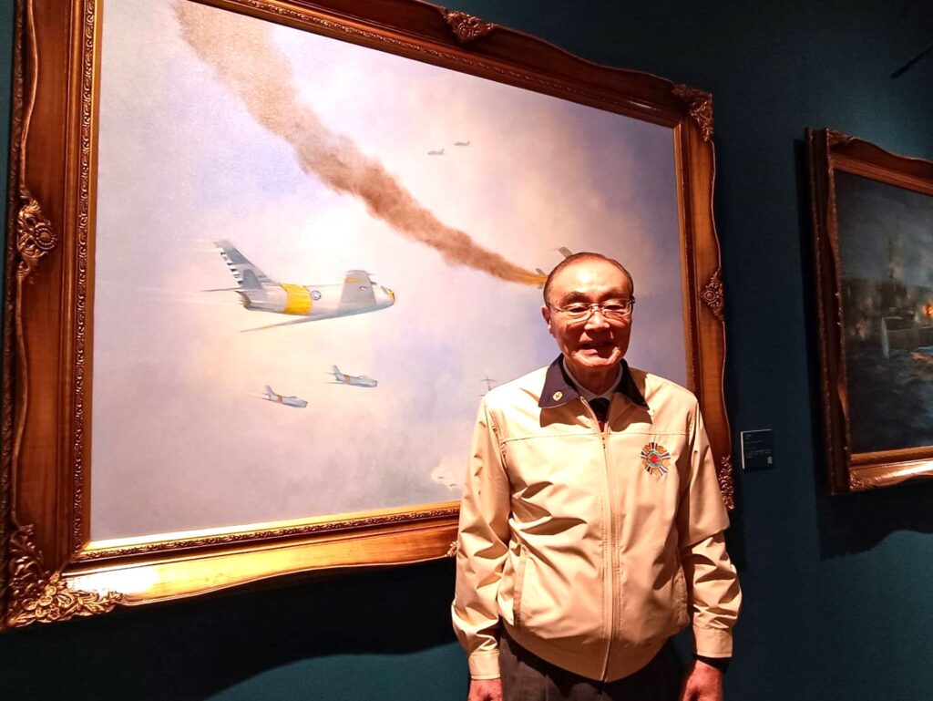 退輔會主任委員馮世寬看到胡四維〈台海空戰〉描繪空戰的作品，感觸頗深。（記者 陳安婷/攝）