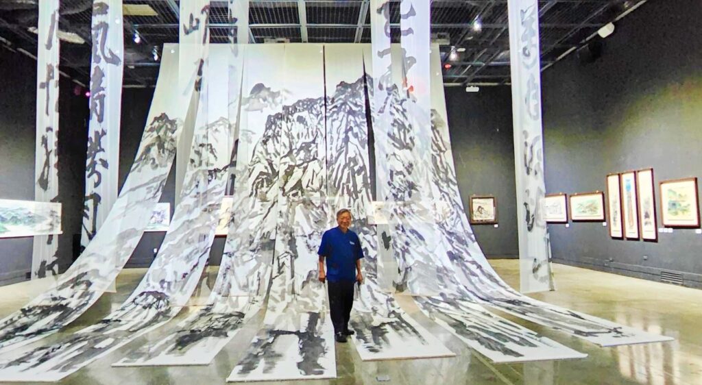 ▲這次推出以水墨為主軸的巨幅裝置藝術，林永發在作品展示現場中顯得極為渺小，足見作品的高難度創作過程。（記者 辛澎祥/攝）