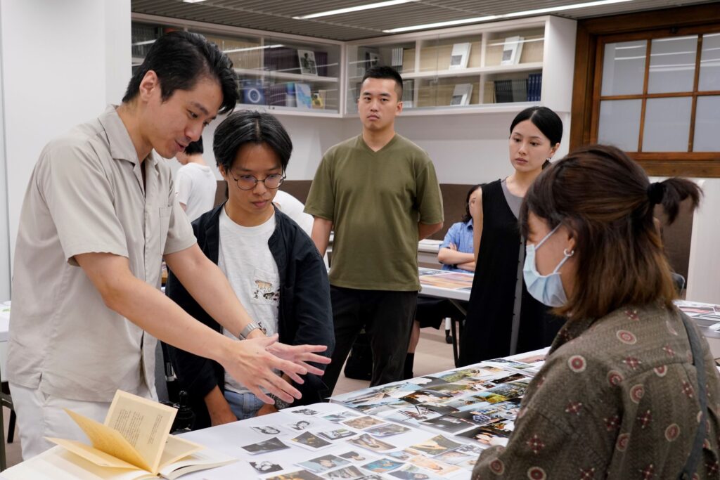 講師蔡胤勤（左一）與黃冠慈（左二）透過鋪展於桌面的影像與學員攝影藝術書籍編輯發想。（圖/國家攝影文化中心提供）