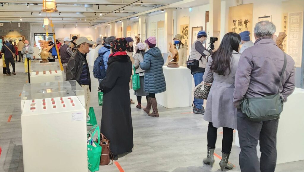 ▲藝術家作品聯展在中原文創園區1號倉展出,觀賞者與藝術家交流熱絡。(記者 辛澎祥/攝)