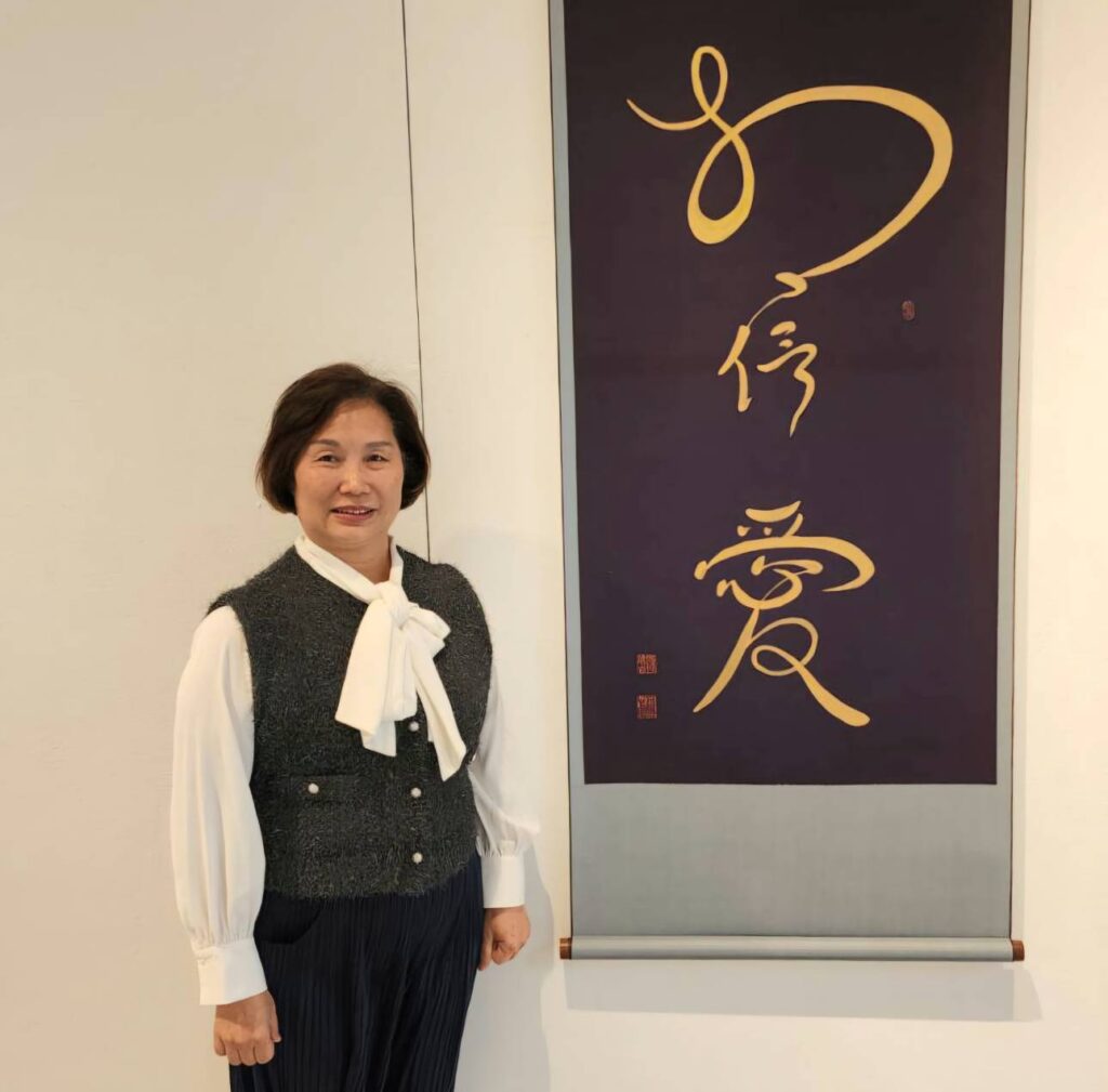 ▲和氣大愛文教基金會董事長段傳芬,在孫端吉教授所闡述的愛與孝作品前留影,對此極具正面意義的展覽賦予高度期待。(記者 辛澎祥/攝)