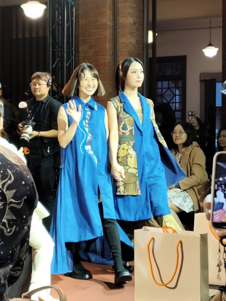 青年設計師以史博館12件館藏圖像為靈感, 讓「NCA時尚秀」充滿驚喜,左為亞藝文創協會執行長王贒勲穿著以《新莽大泉五十銅範》為主題演繹的拼接長版上衣。(記者 陳安婷/攝)
