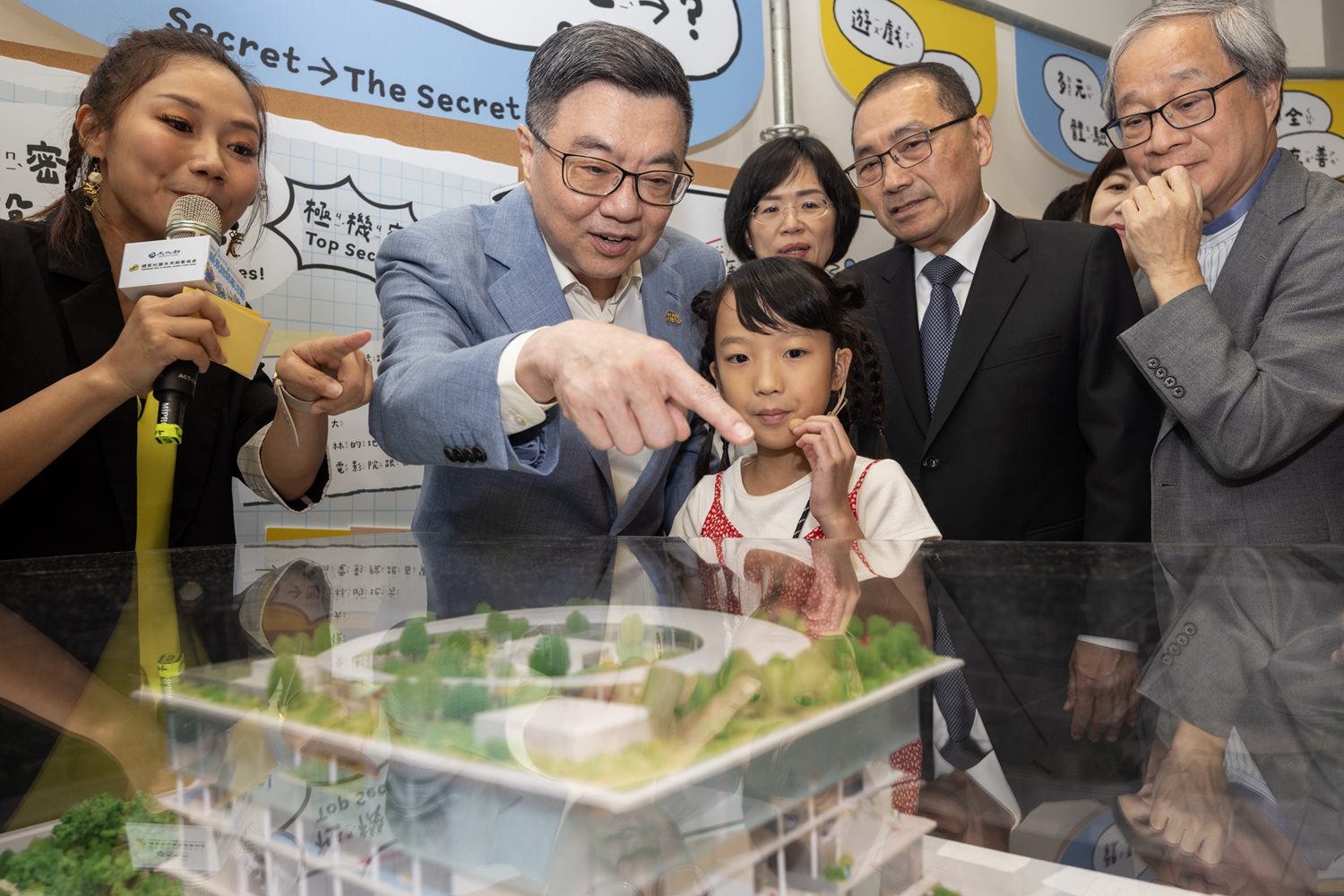 小小主持人何宇心（前中）帶領貴賓們參觀國家兒童未來館願景館開幕特展「我跟大家說一個秘密」，透過設計模型分享彼此對兒未館的多元想像。（圖/文化部提供）