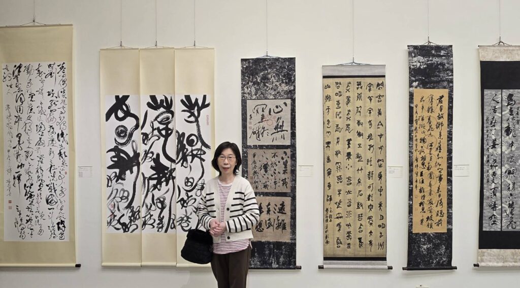▲雲心書會會員也是施春茂教授的學生侯淑慧,在她的展出作品「春耕夏耘秋收冬藏」前留下展歷,創作技藝愈趨成熟。(記者 辛澎祥/攝)
