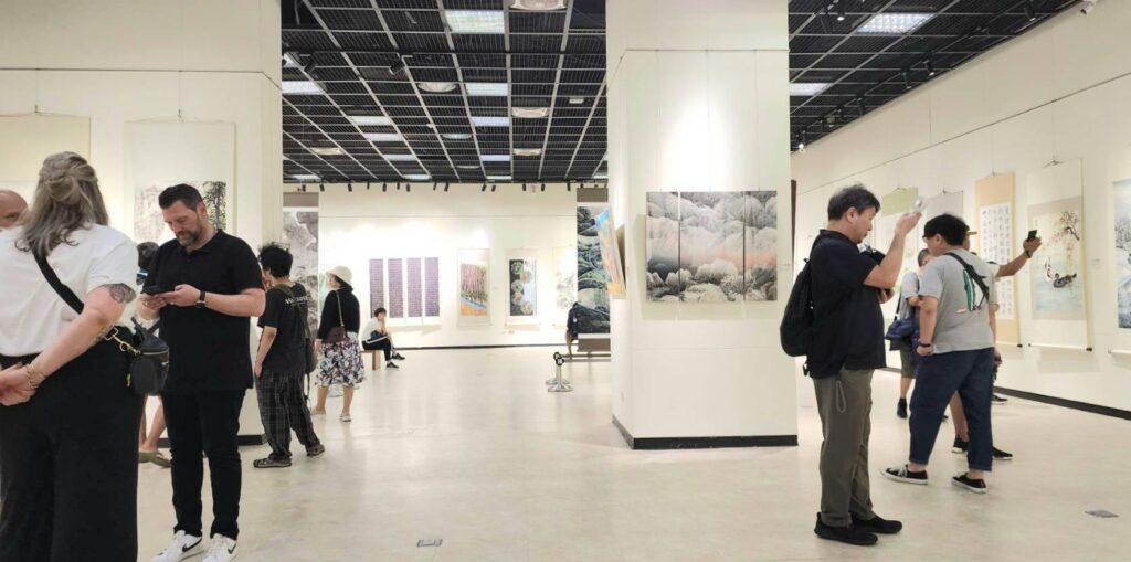 ▲國內外遊客與民眾在1日開展首日即在展場欣賞聯展作品,場面熱烈。(記者 辛澎祥/攝)