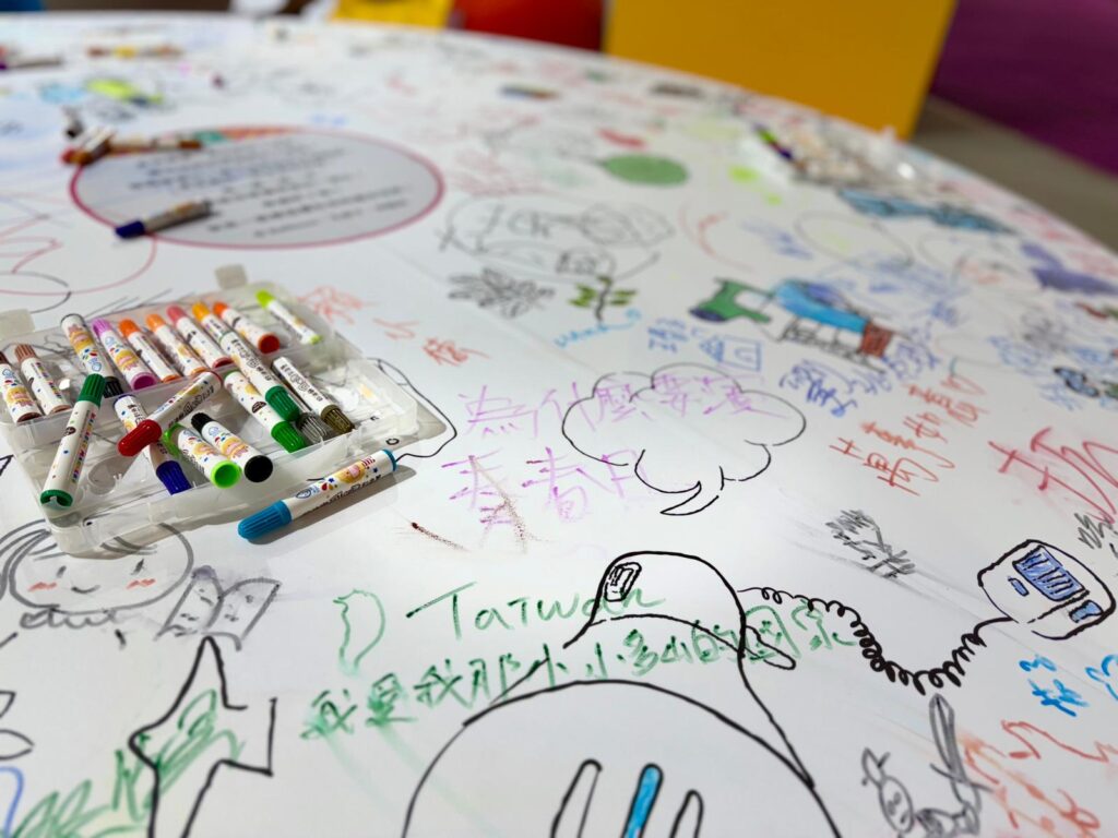 展場設計突破傳統框架，保留大面積的圓形廣場，結合插畫名家作品做為共創區，讓孩子們一起即興塗鴉、故事接力。（圖/文化部提供）