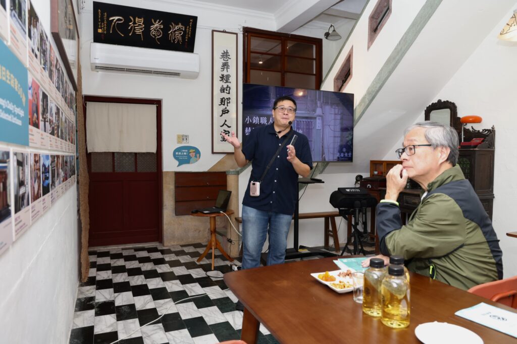 返鄉青年彭仁鴻（站者）向李遠部長說明將老鎮長邱金魚故居作為老屋再生及社區實踐場域。（圖/文化部提供）