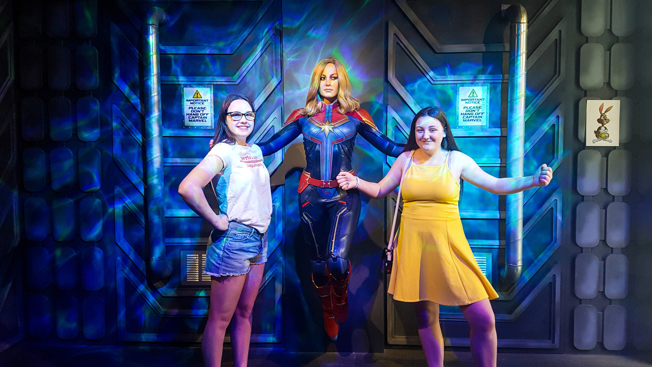 tow girls posing with a captain marvel wax figure at madame tussauds blackpool