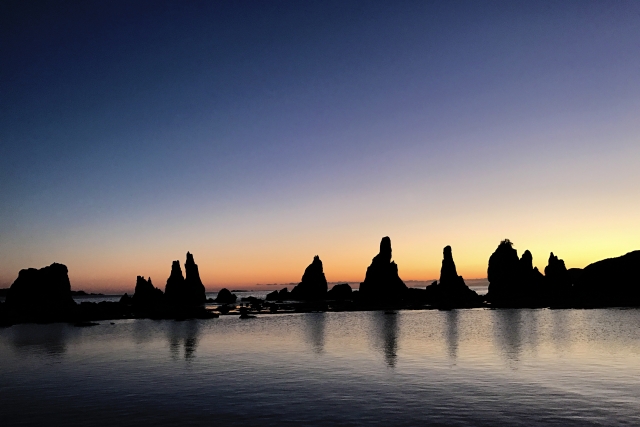 明け方の海と岩の影