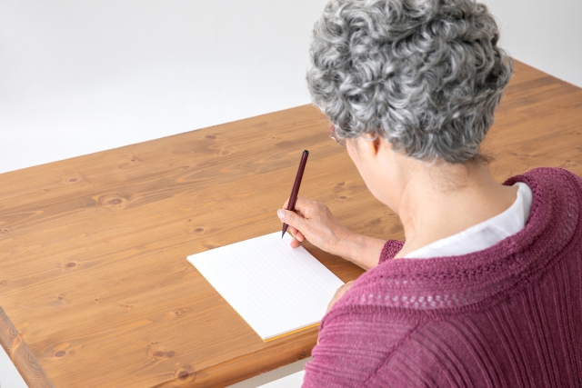 手紙を書く高齢女性