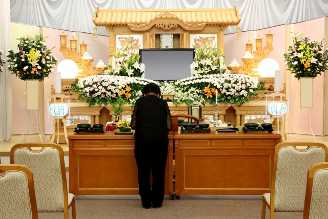 祭壇に」手を合わせる年配女性