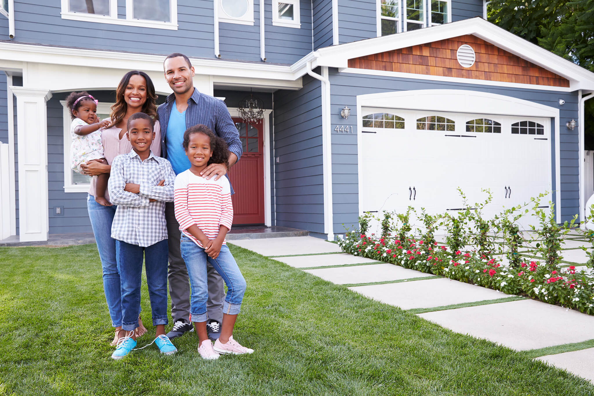 happy family standing outside their new home