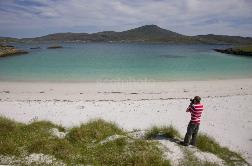 I5D9585 Tourist Looks At Castlebay From Beach On Vatersay Hebrides