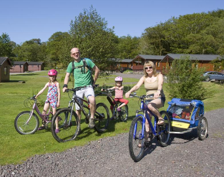 I5D0356 Panoramic Of Family On Holiday With Their Bikes