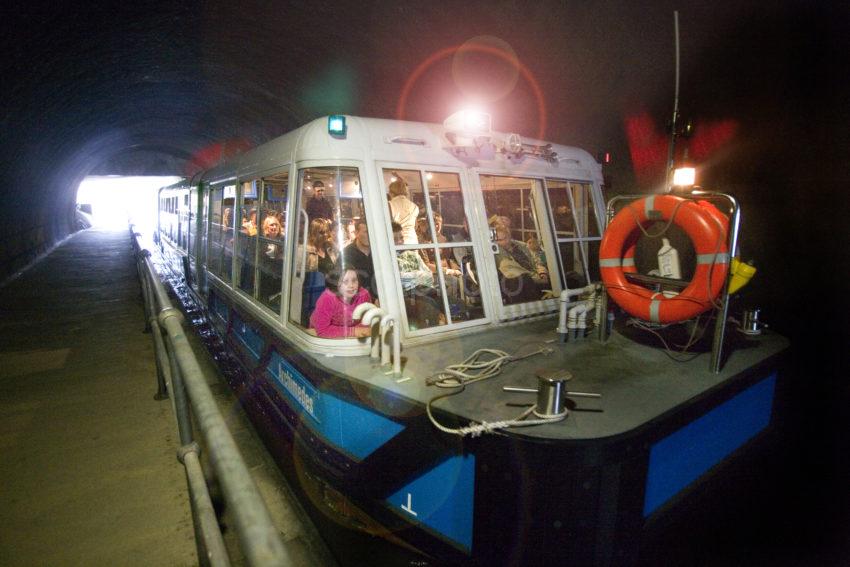 WY3Q3542 Boat Passes Through Dark Tunnel