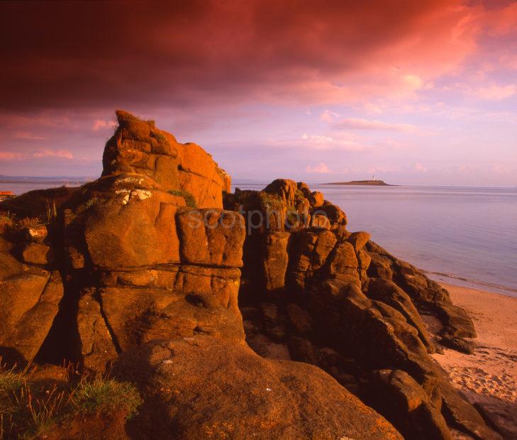 Sandstone Cliffs Bathed In Late Evening Light On The South Coast Of Arran With Pladda Isle In Distance Island Of Arran