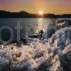 ICE ON ROCKY SHORE OF LOCH ASSYNT AT SUNSET